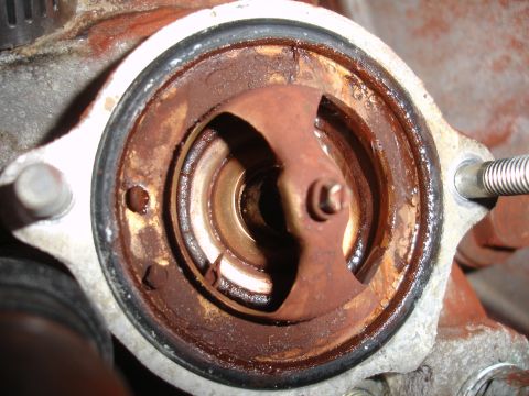 1989 Ford Taurus - Close-up of a corroded engine part, likely a thermostat housing, showing signs of wear and tear.