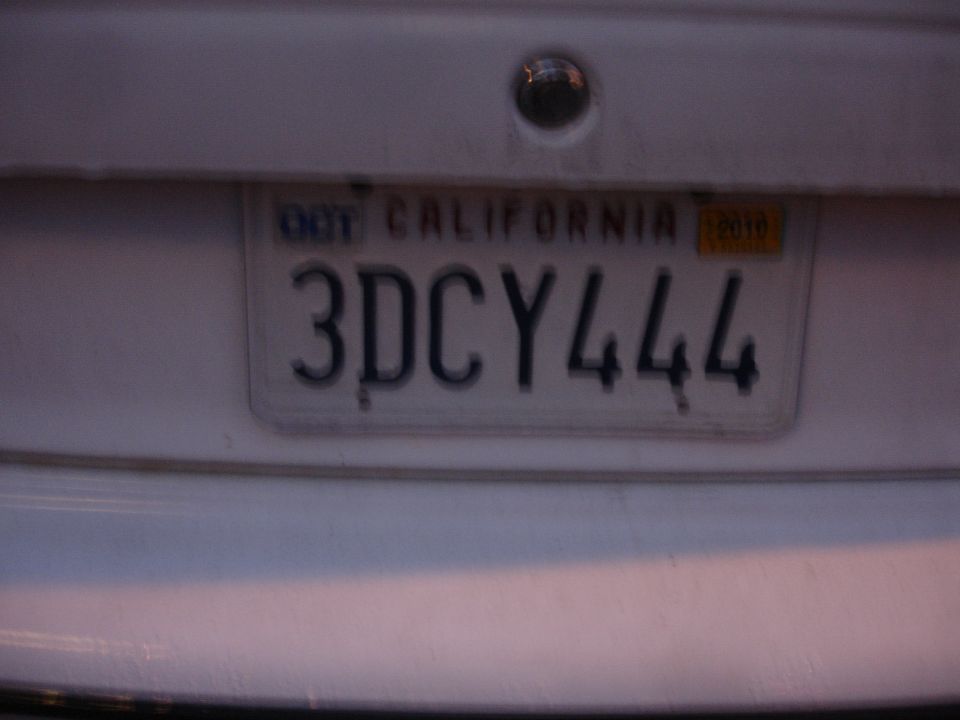 White car's rear bumper with a California license plate reading 3DCY444 and a 2010 sticker
