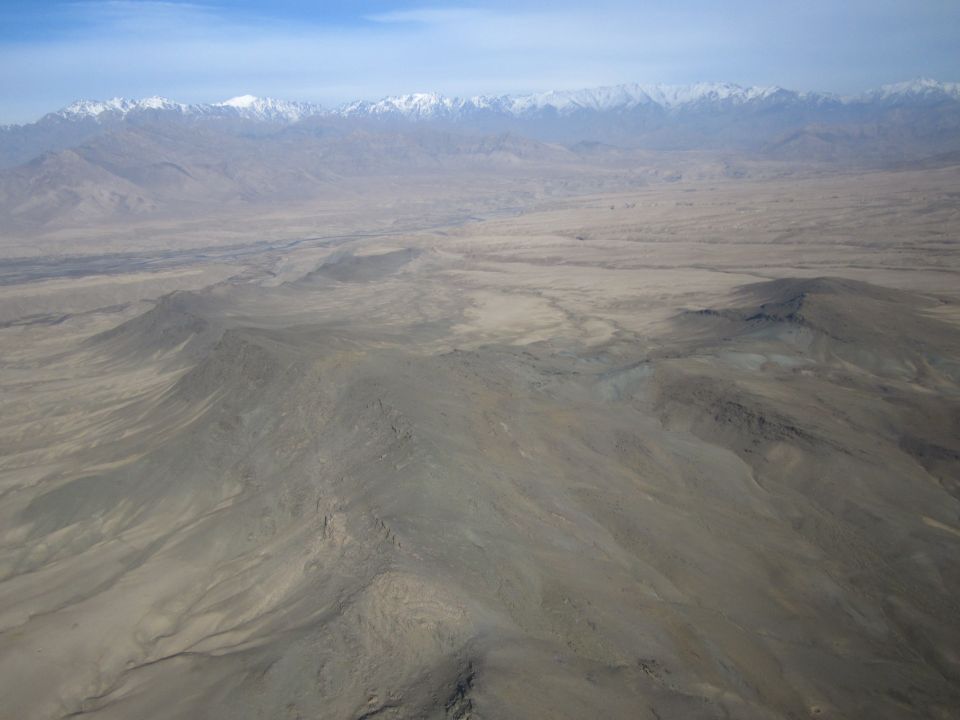 arid mountain landscape with snow-capped peaks in distance