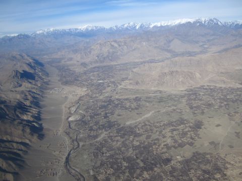 2003 Jeep Wrangler - An expansive aerial perspective captures a remote valley landscape, characterized by a meandering river and distant, snow-dusted mountain p…