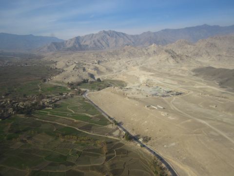 2003 Jeep Wrangler - A wide shot captures a valley with terraced fields, a winding road, and mountains under a clear sky.