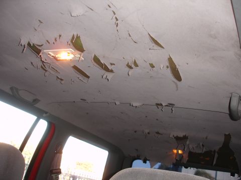 1992 Ford Explorer - The headliner in this vehicle is severely damaged, with large pieces of fabric peeling off.