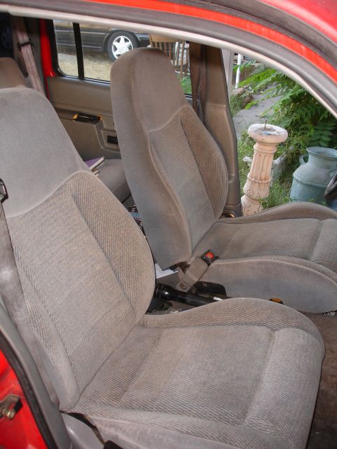1992 Ford Explorer - The interior of a vehicle shows gray fabric seats and seatbelts, with a flashlight visible on the floor.