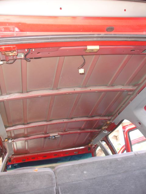 1992 Ford Explorer - The interior ceiling of a vehicle, showing the exposed metal framework and wiring before headliner installation.