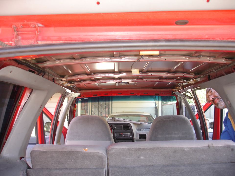 SUV interior with exposed ceiling, gray seats, and another vehicle visible through the windshield