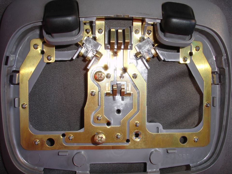 Overhead dome light assembly with two black push buttons and brass electrical contacts