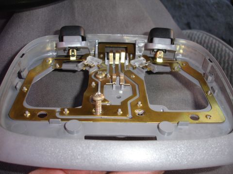 1992 Ford Explorer - This is a close-up view of a vehicle's interior light assembly, showing its internal wiring and mounting points.
