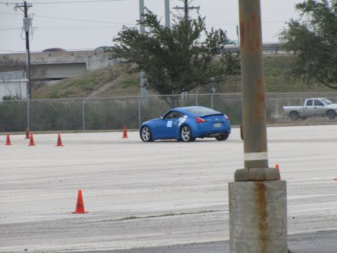 2003 Mazda Protege - A blue sports car navigates a course marked by orange cones on a cloudy day.