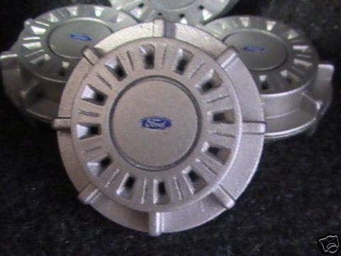 1999 Ford Crown Victoria - Set of four silver Ford hubcaps with blue Ford emblems are displayed.