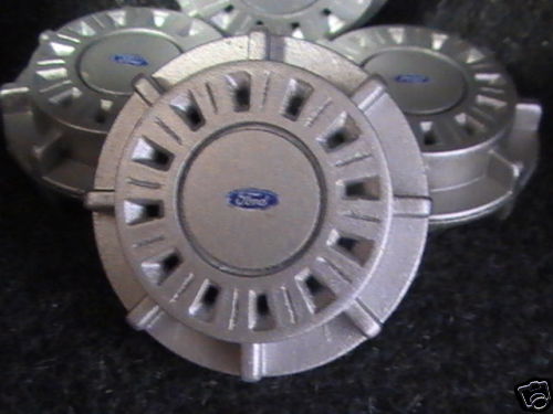 Four silver Ford hubcaps with blue Ford logos
