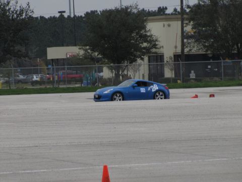 2003 Mazda Protege - A blue sports car is visible on a paved surface, with orange cones in the foreground.