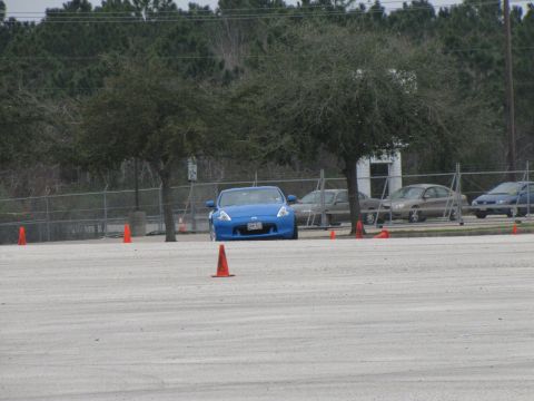 2003 Mazda Protege - A blue sports car is parked on a paved lot with orange cones visible around it.