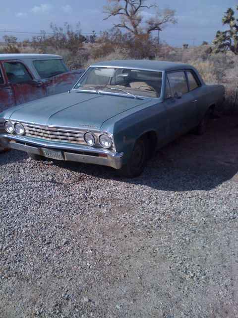 1968 Ford Mustang - A light blue 1966 Chevrolet Chevelle sedan sits in a gravel lot next to another vehicle.