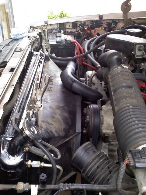 1992 Ford Bronco - Close-up view of an engine bay, showing the radiator and fan shroud secured with locking pliers.