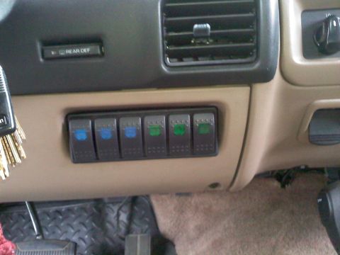 1992 Ford Bronco - A close-up view of the vehicle's dashboard shows auxiliary switches and a rear defroster button.