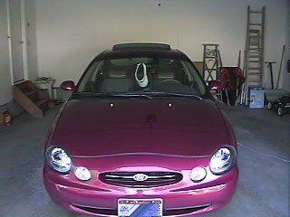 1999 Ford Taurus - Front view of a maroon 1999 Ford Taurus parked inside a garage.