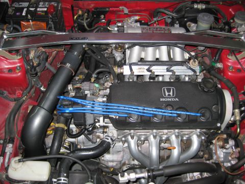 1993 Honda Civic - Close-up of a Honda engine bay, showing the engine block, intake manifold, and spark plug wires.