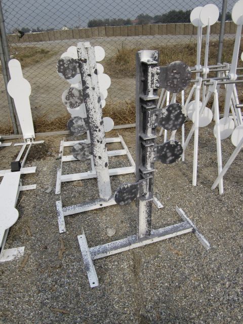 2003 Jeep Wrangler - Metal shooting targets with spinning plates are arranged on stands in an outdoor area.