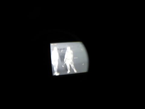 2003 Jeep Wrangler - Thermal imaging captures two figures, one appearing to hold a weapon, in a dark environment.