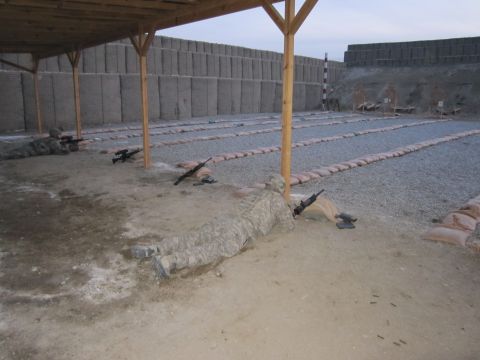 2003 Jeep Wrangler - A military shooting range is set up with multiple lanes, sandbags, and concrete barriers, as soldiers lie in position with their rifles.