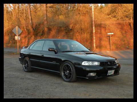 1998 Subaru Legacy - 1998 Subaru Legacy sedan parked on a dirt road during golden hour.