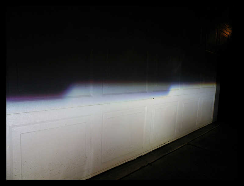 Headlight beam pattern projected onto a white garage door