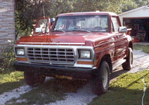 1969 Ford Mustang - This red pickup truck is parked in a driveway with a garage in the background.