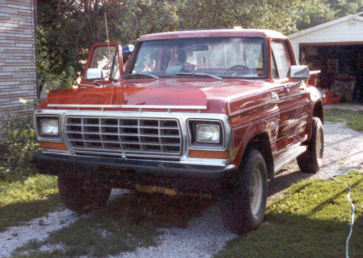 red pickup truck parked in driveway, driver's door open