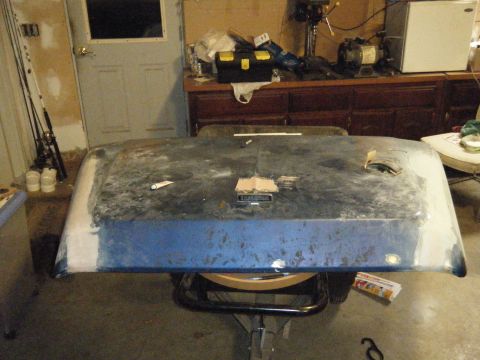 1978 Ford Bronco - Hood in primer, possibly for a 1978 Ford Bronco, is shown in a workshop setting.