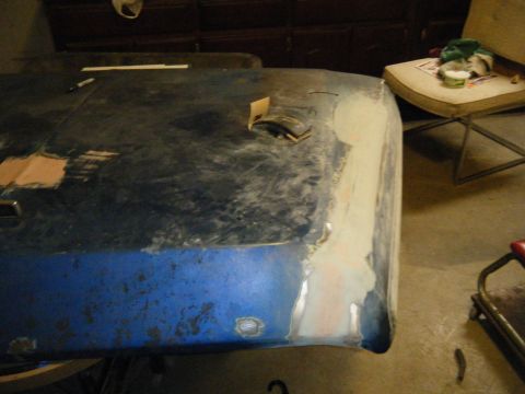 1978 Ford Bronco - Car hood is being repaired with body filler and primer, showing signs of damage and restoration work.