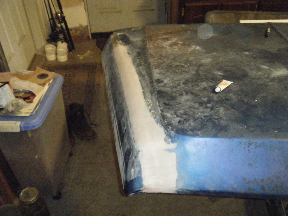 car hood with body filler applied to edge, tube of sealant on top