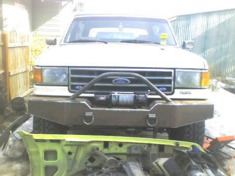 1989 Ford Bronco - Front view of a white Ford Bronco with a custom bumper and winch, parked outdoors.