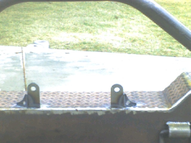 Close-up of custom bumper brackets welded onto diamond plate