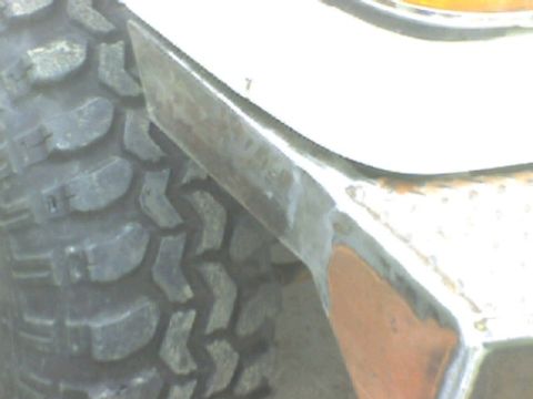 1989 Ford Bronco - A close-up view shows the tread of a large tire next to a vehicle's metal fender flare.