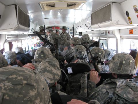2003 Jeep Wrangler - Interior of a crowded white shuttle bus packed with soldiers in ACU digital-camouflage uniforms, helmets, body armor and rifles, shot from…