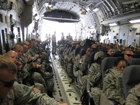 2003 Jeep Wrangler - Interior view of a military transport aircraft filled with seated soldiers.