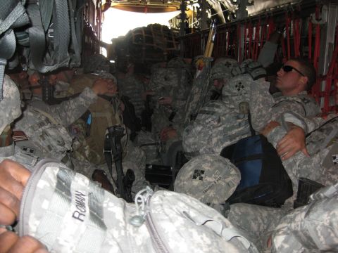 2003 Jeep Wrangler - A crowded cargo plane interior shows soldiers seated amongst their gear, suggesting transport during a military operation.