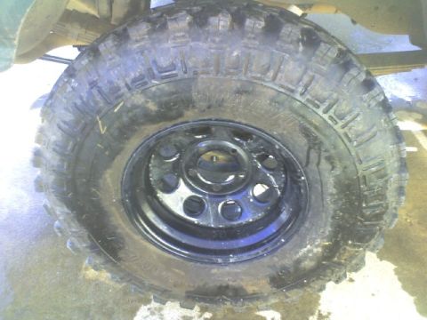 1989 Ford Bronco - Close-up of a off-road tire mounted on a black steel rim.