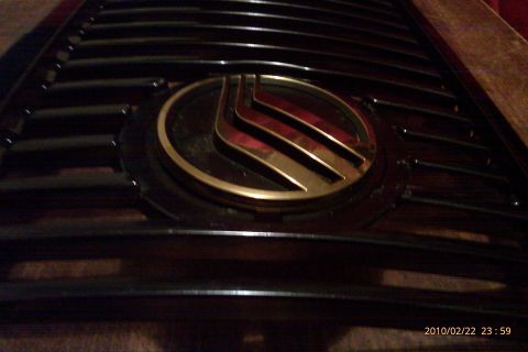 2000 Mercury Grand Marquis - Close-up of a dark grille with a gold Mercury emblem.