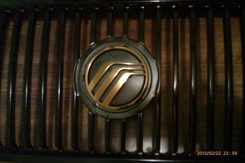 2000 Mercury Grand Marquis - Close-up of a Mercury emblem mounted on a vehicle's front grille.