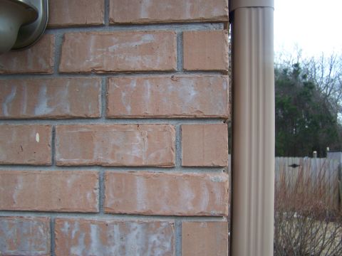 1978 Ford Bronco - A close-up view of a brick wall and a downspout, with a hint of the outdoors in the background.
