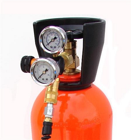1993 Ford Bronco - Close-up view of an orange gas cylinder equipped with two pressure gauges and brass fittings.