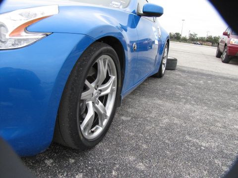 2003 Mazda Protege - A blue sports car is parked on asphalt, with another vehicle visible in the background.