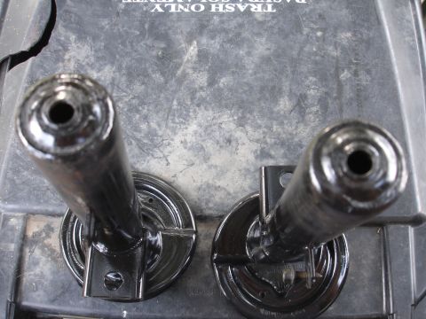1995 Ford Taurus - Close-up view of two automotive suspension parts resting on a dark, textured surface.