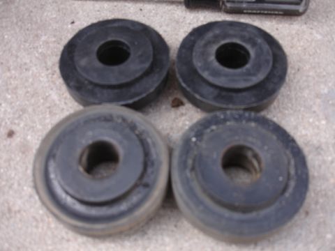1995 Ford Taurus - Four rubber bushings are shown, likely suspension components, against a concrete background.