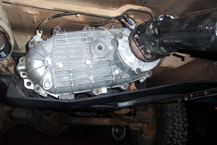 Aluminum transfer case mounted under a truck with driveshaft attached