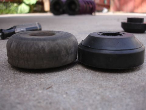 1995 Ford Taurus - A comparison of a worn rubber bushing next to a new one, likely for automotive suspension.