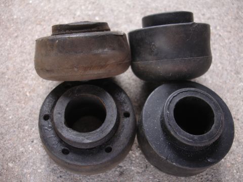 1995 Ford Taurus - A set of four rubber suspension bushings are shown, with some showing wear and tear.