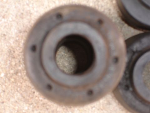 1995 Ford Taurus - Several automotive suspension bushings are shown, resting on a textured surface.