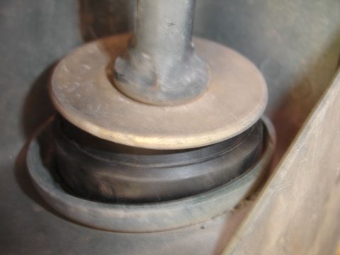 1995 Ford Taurus - A close-up view of a rubber suspension bushing compressed between two metal plates, likely part of a vehicle's chassis.